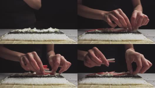 寿司师傅手的特写把螃蟹放在海苔叶和蟹肉上。寿司制作过程。卷寿司卷高清在线视频素材下载