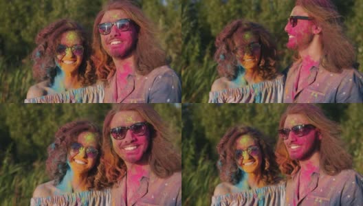 胡里节期间，有着彩色面孔和头发的混血夫妇在户外玩耍高清在线视频素材下载