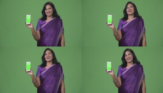 成熟快乐美丽的印度女人微笑着展示手机高清在线视频素材下载
