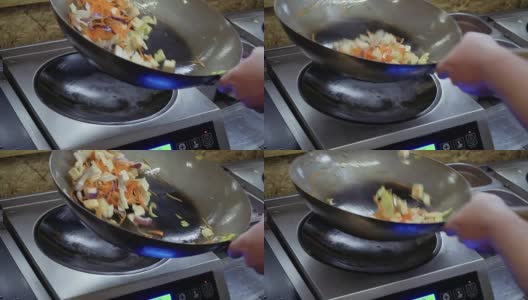 厨师在热锅中混合油炸材料高清在线视频素材下载