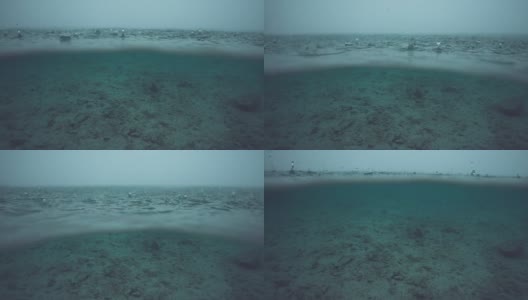 半水下:深蓝色的海洋被困在一场强烈的热带暴雨中。高清在线视频素材下载