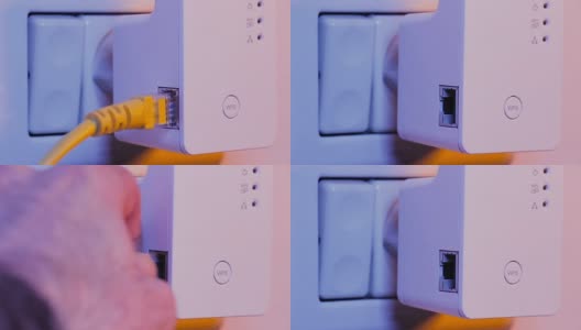 人从墙上的电源插座上的WiFi扩展器设备上拔出以太网线高清在线视频素材下载