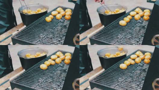 新鲜的土豆，放在烧烤架上翻个面高清在线视频素材下载