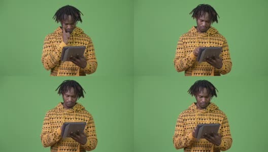 年轻英俊的非洲男子使用数字平板电脑和思考高清在线视频素材下载