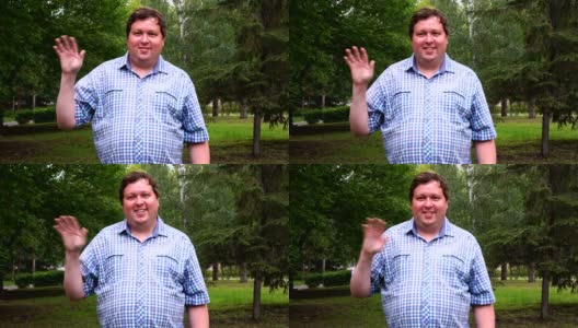 一个穿着格子衬衫的胖子在公园里开心地用手敬礼高清在线视频素材下载