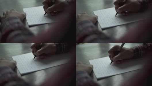 Kuchl /奥地利- 2019年8月22日:一名男子在棕色木桌上的白纸上书写信件。复古信，婚礼爱情故事，新郎誓言。缓慢的运动。关闭了。高清在线视频素材下载