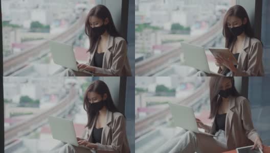 年轻美丽的亚洲女性戴着口罩使用笔记本电脑在家办公高清在线视频素材下载