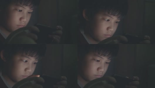 一个男孩在暗室里玩游戏高清在线视频素材下载