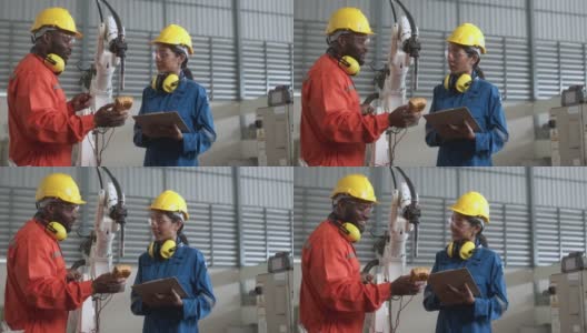 多样化团队工程师合作男女技术员维护控制继电器机器人手臂系统焊接与平板控制操作过程工作重工业4.0制造工厂高清在线视频素材下载