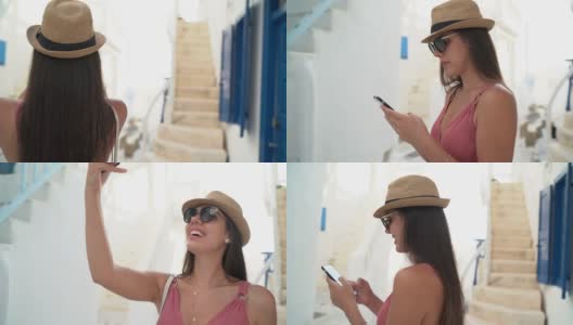 一名年轻女子在希腊米科诺斯镇使用智能手机高清在线视频素材下载
