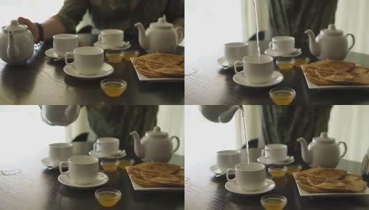 一个男人的手的特写，他正在桌子上吃早餐，倒茶高清在线视频素材下载