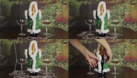 寒假的概念。圣诞新年背景。室内桌上放着一瓶香槟和一对酒杯。双手放在瓶子上。长长的银珠摆在桌上。高清在线视频素材下载