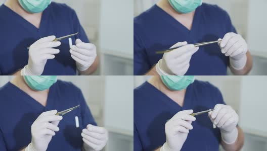 在医院里，医生戴上无菌白手套和口罩，仔细检查医疗器械。身着职业装的外科医生正在检查手上的夹钳高清在线视频素材下载