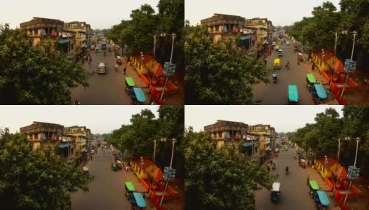 老加尔各答的夜晚街道，有汽车，行人，可以俯瞰摩托车，嘟嘟车，破旧的四层建筑，晾晒的衣服，绿树高清在线视频素材下载