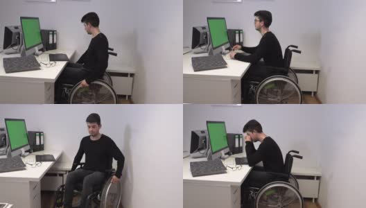 一个坐在轮椅上的经理，一个不能在他工作的电脑前行走的年轻人，慢动作高清在线视频素材下载