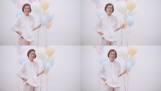 亚洲活跃的老年妇女用彩色气球庆祝生日高清在线视频素材下载