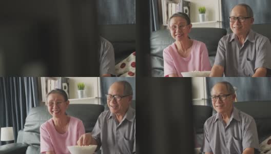 亚洲祖父母一起在家看电影。老人微笑着用遥控器看电视，笑得很开心。家庭中退休人员的休闲时间和生活方式活动。高清在线视频素材下载
