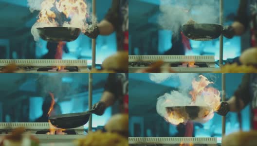 专业厨师烹饪火焰风格。用明火在平底锅中准备菜肉。厨师在商业厨房的煤气灶上煎拌食物。餐馆里，一名男子正在用火红的平底锅煎牛排。高清在线视频素材下载