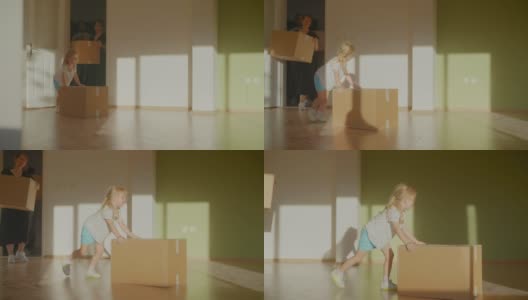一个年轻的家庭带着一个孩子搬着纸板箱进了他们的新家高清在线视频素材下载