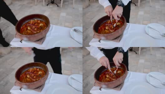 服务员把用蔬菜调味的章鱼触手端到盘子里给客人高清在线视频素材下载