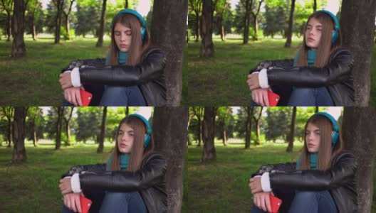 十几岁的女孩在城市公园听音乐高清在线视频素材下载