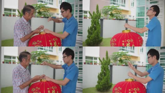 亚洲华人父亲和儿子准备大红灯笼在他们家的前院在中国新年前夕高清在线视频素材下载