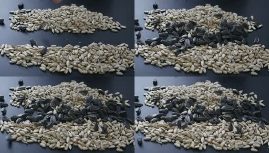 葵花籽落在一堆剥皮的葵花籽上高清在线视频素材下载