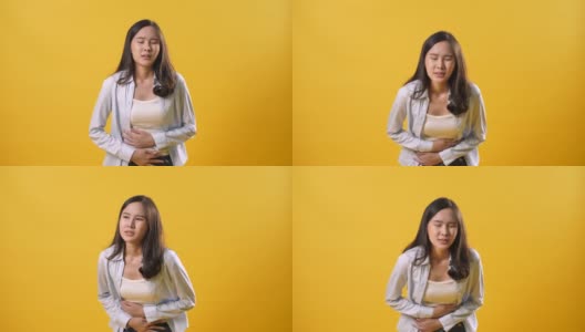 妇女胃痛痛分离在黄色背景上高清在线视频素材下载