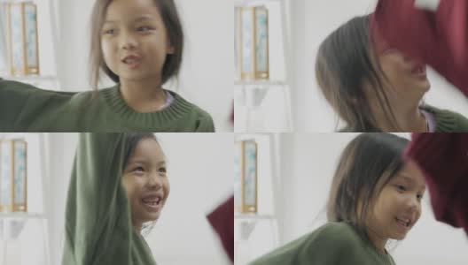 亚洲女孩穿着绿色毛衣和姐姐在家里跳舞，生活理念。高清在线视频素材下载