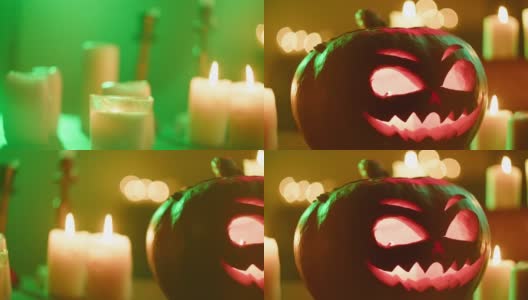 杰克灯和燃烧的蜡烛特写。木桌上摆放着里面有火苗的雕刻南瓜。万圣节的符号，吓人的脸，传统的秋季节日装饰高清在线视频素材下载