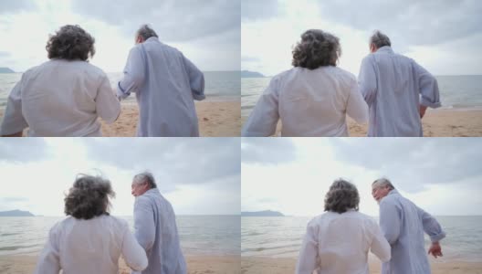 老人和妻子带着幸福的情绪一起跑向海滩。有生活方式、情感和退休观念的人。慢动作镜头。高清在线视频素材下载