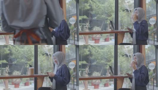 快乐多元的亚洲穆斯林年轻女子坐在café桌喝咖啡高清在线视频素材下载