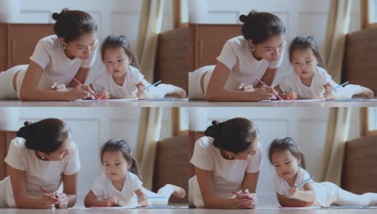 有爱心的亚洲妈妈帮助孩子的女儿用铅笔画画高清在线视频素材下载