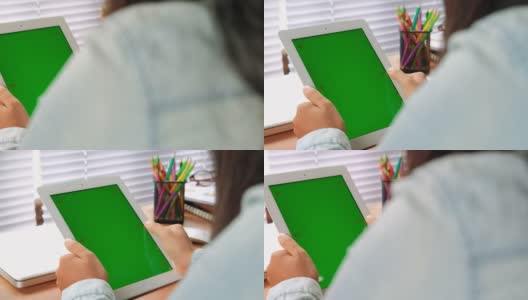 女人手握平板电脑与一个绿色屏幕的内容显示。多莉拍摄了4k视频高清在线视频素材下载