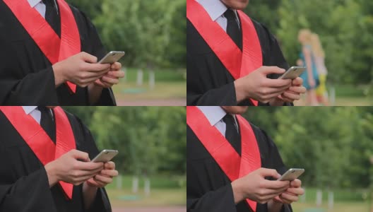 男毕业生用智能手机聊天，收发电子邮件，用现代科技高清在线视频素材下载