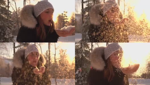 慢镜头:在神奇的冬天，年轻女子在夕阳下吹着雪花高清在线视频素材下载
