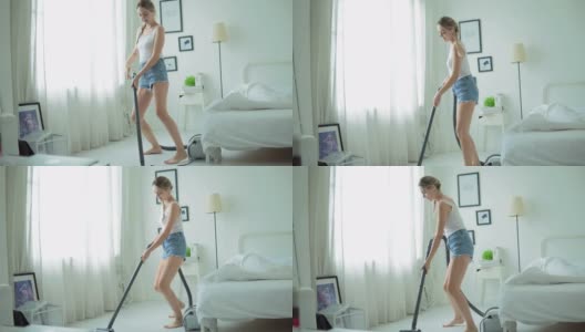 年轻女子有乐趣打扫房子用吸尘器客厅高清在线视频素材下载