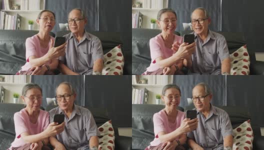 亚洲老年妇女和老人手持手机或平板电脑，在家里与儿子、女儿、孙子、孙女进行视频通话和微笑。祖父母对通过互联网交流感到高兴。高清在线视频素材下载