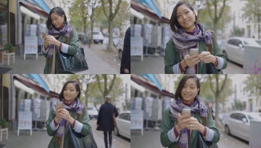 微笑的女人在城市的人行道上使用智能手机高清在线视频素材下载
