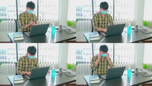 “商人佩戴防护口罩、使用洗手液在办公室工作杀灭covid-19、预防感染和大流行”的4k视频画面高清在线视频素材下载