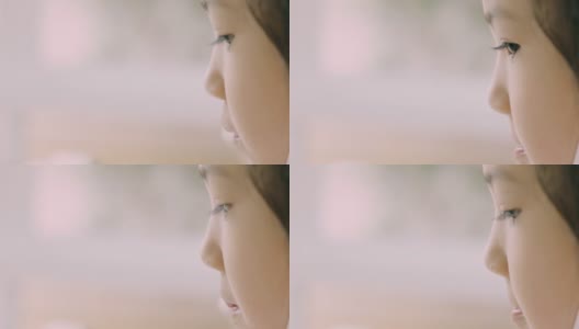 可爱的亚洲小女孩的临场临场侧视在哭泣，通过她的眼睛和美丽的肤色来表达人们的悲伤、不快乐、沮丧和悲伤。高清在线视频素材下载