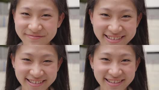 中国少年笑着开心。在模糊的背景下，欢快的亚洲女孩站在户外看着相机的特写肖像。高清在线视频素材下载