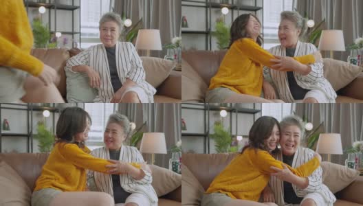 幸福的亚洲家庭偷拍的女儿拥抱祖父母妈妈年长的年长的妈妈舒适地放松在客厅的沙发沙发上，美丽的家庭的母亲和女儿在一起，拥抱和亲吻在家里高清在线视频素材下载