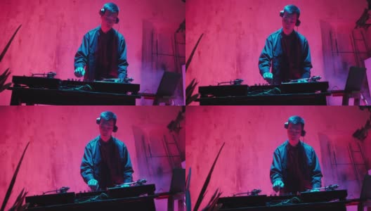 Asian Appearance的现代DJ在霓虹灯下演奏音乐。高清在线视频素材下载