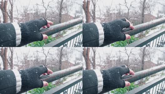 外面下雪时，一个男人的手指在旧铁栅栏上移动高清在线视频素材下载