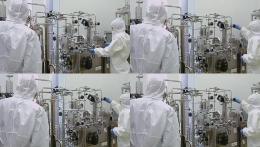 身着防护服的科学家们在大桶上工作高清在线视频素材下载