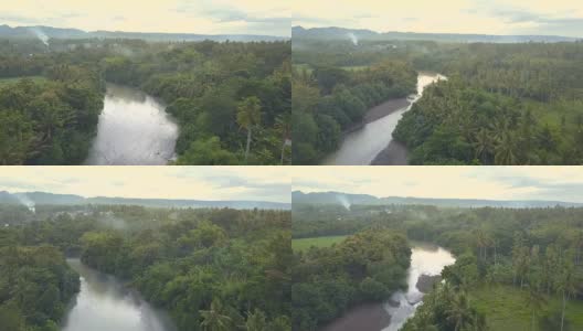 天线:在美丽的杂草丛生的丛林中，蜿蜒的河流附近的传统村庄高清在线视频素材下载
