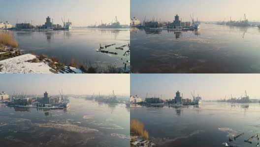 全景式的工业区周围的北港河上覆盖着冰，码头的起重机和商业船只高清在线视频素材下载