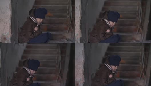 冻僵的、机警的男孩在一所破旧的老房子里取暖高清在线视频素材下载
