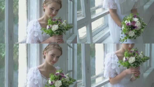 美丽的女孩穿着复古的白色连衣裙坐在窗台上，闻着花香，慢镜头高清在线视频素材下载